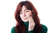 A woman in pain exploring ways to restore gums after gum recession in South Ogden & Kaysville, UT.